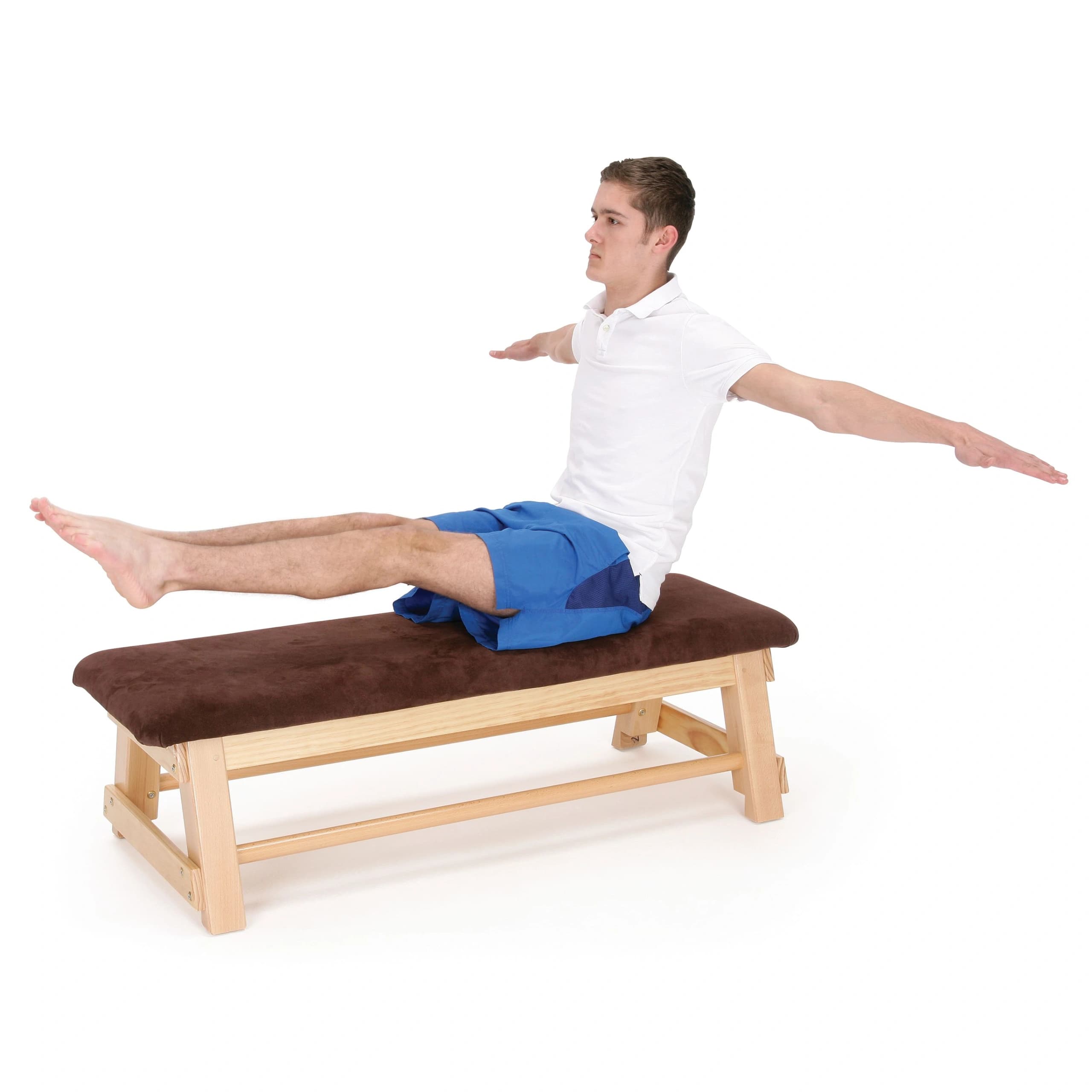 A man in a white polo and blue shorts sits on a wooden bar box with a brown hide top, legs extended and arms outstretched.